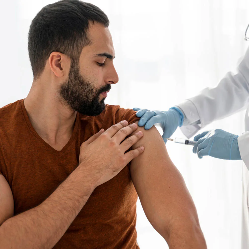 Médico administrando inyección de células madre a un paciente masculino en Bogotá